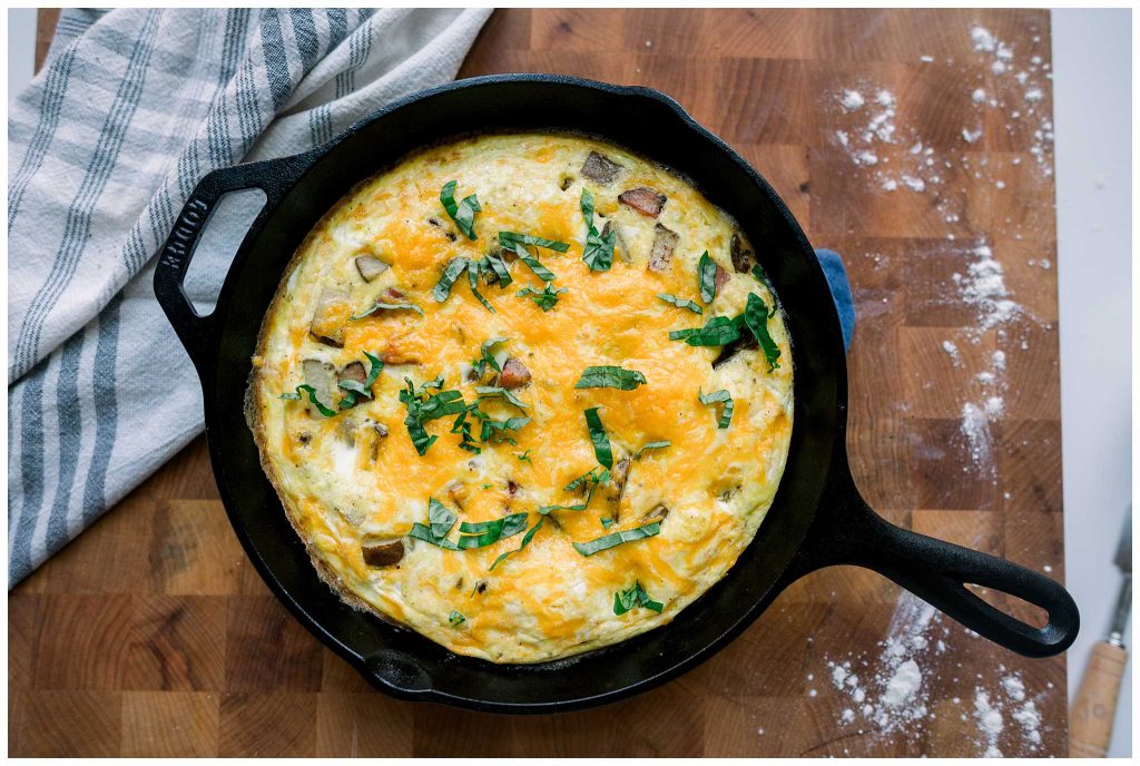 Ham and Potato Frittata in a cast iron skillet with basil on top