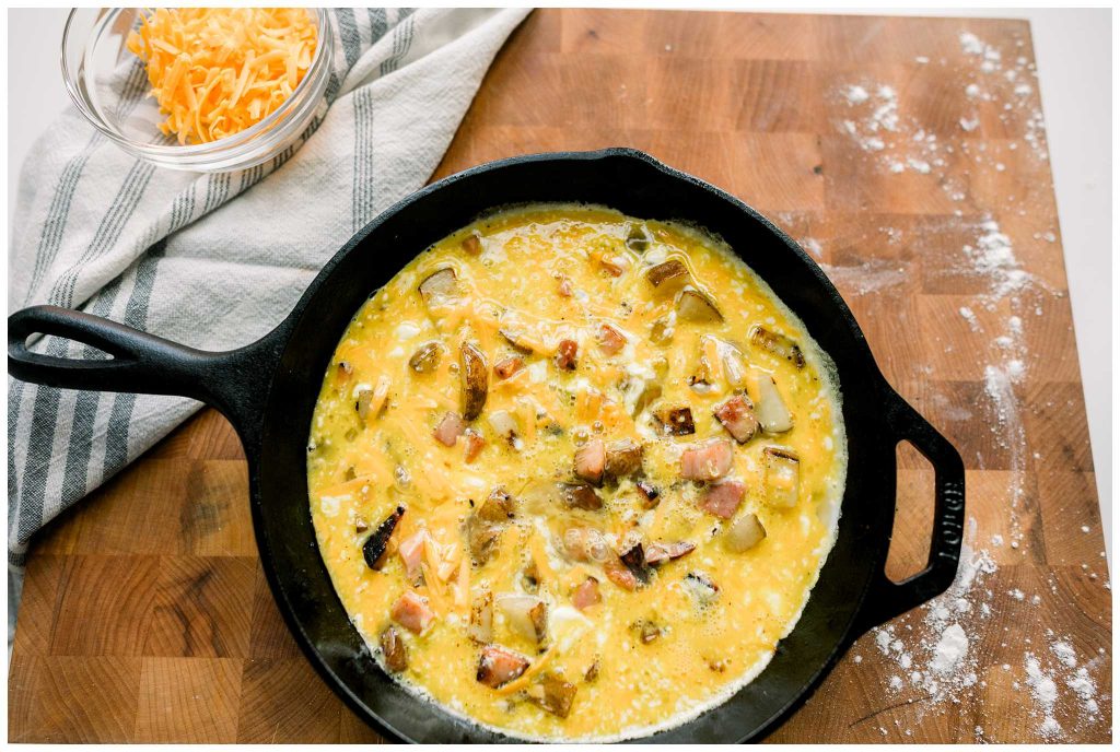 Uncooked Ham and Potato Frittata in a cast iron skillet