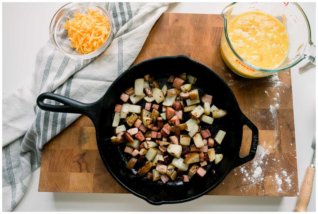 Unassembled Ham and Potato Frittata in a cast iron skillet