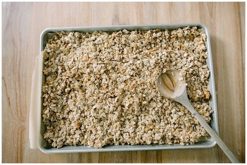 Pressing homemade granola on a pan prior to baking