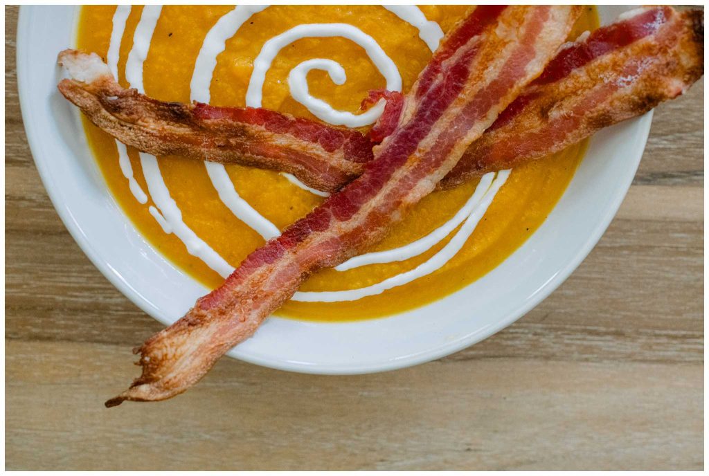 Roasted Butternut Squash Soup In a Bowl With Bacon and Sour Cream