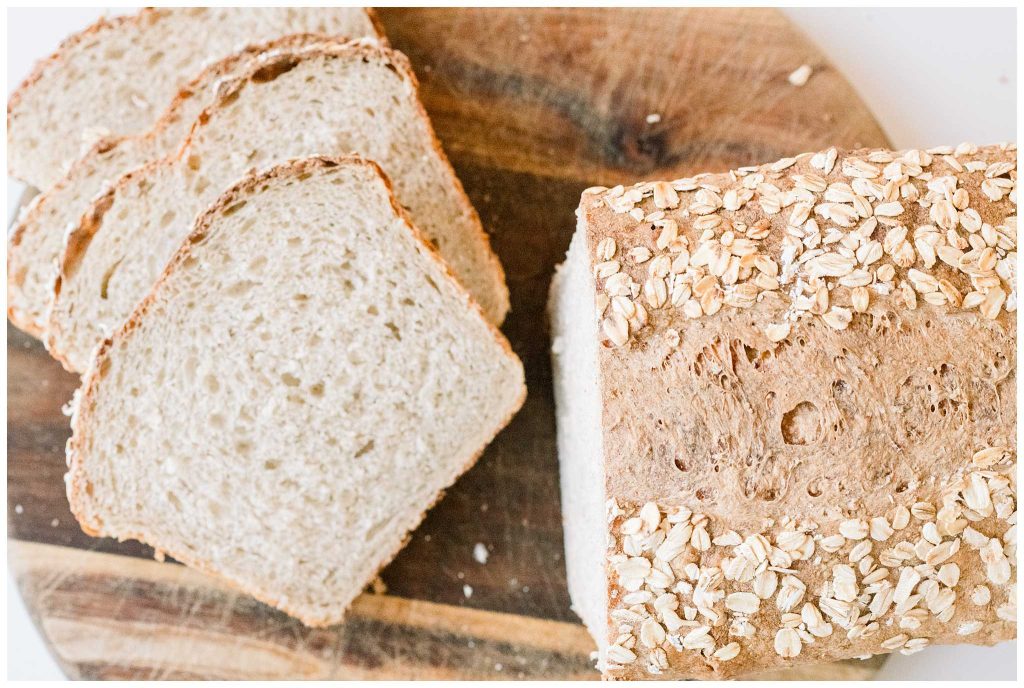 Sourdough Oatmeal Sandwich Bread sliced on a cutting board